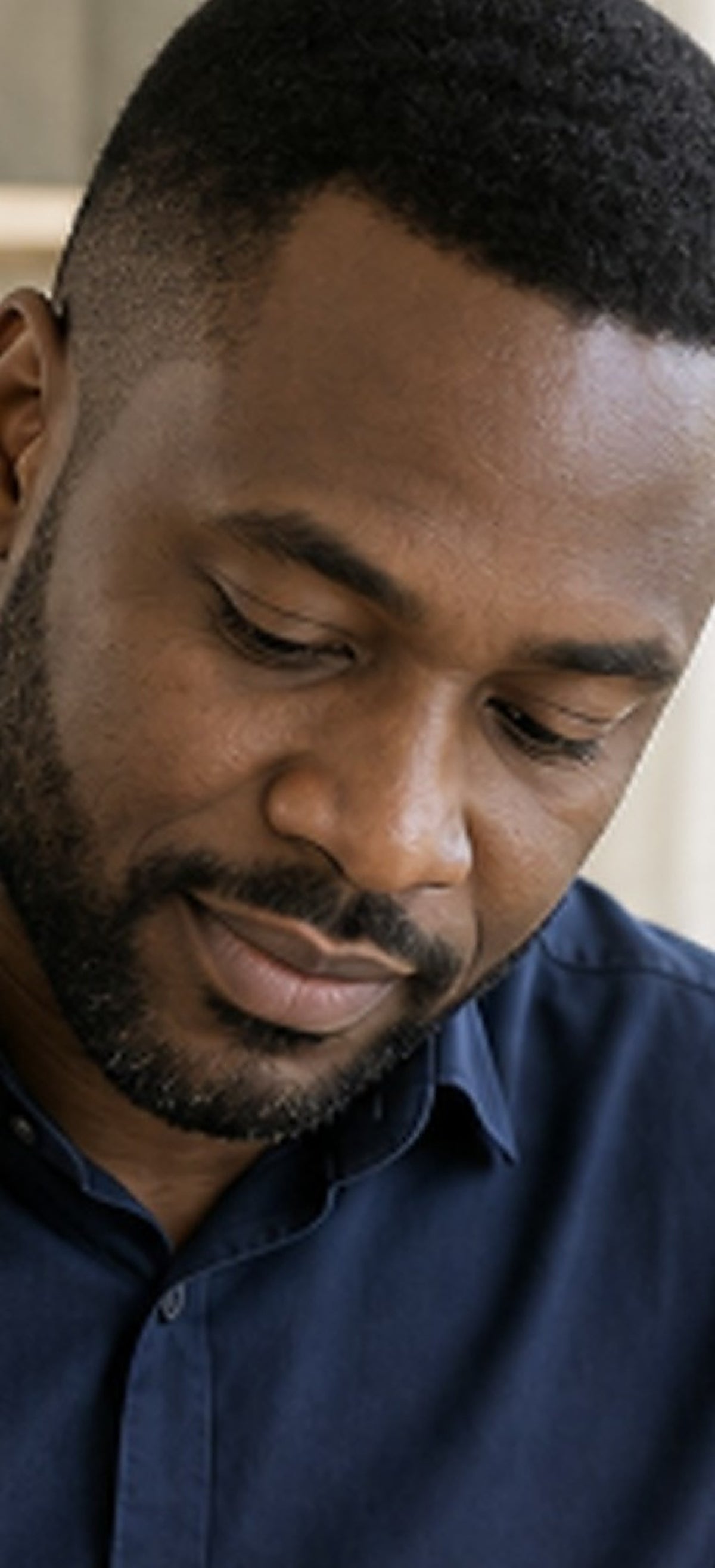 Portrait rapproché d'un homme concentré, le regard baissé sur son travail